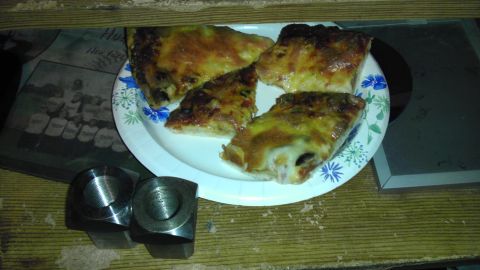 1987 Ford Ranger - A plate of pizza slices sits next to a photograph and two metal components on a wooden surface.