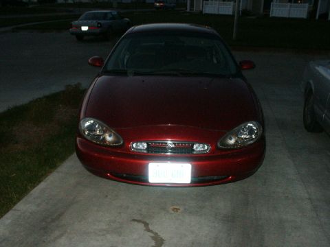 1998 Mercury Sable - Front view of a red 1998 Mercury Sable sedan, showing its headlights and grille.