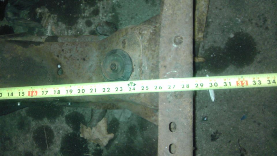 Front suspension part with measuring tape showing 13-34 inches