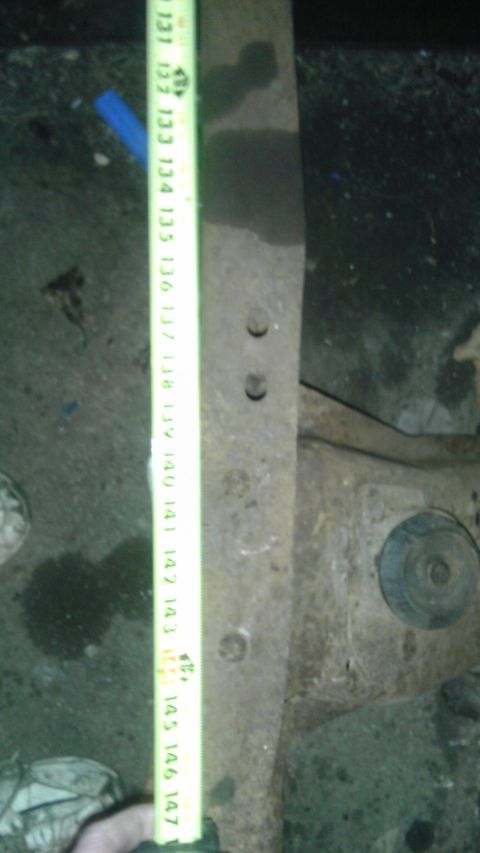 1987 Ford Ranger - A rusted metal part, likely from a vehicle's suspension, is measured with a tape measure.