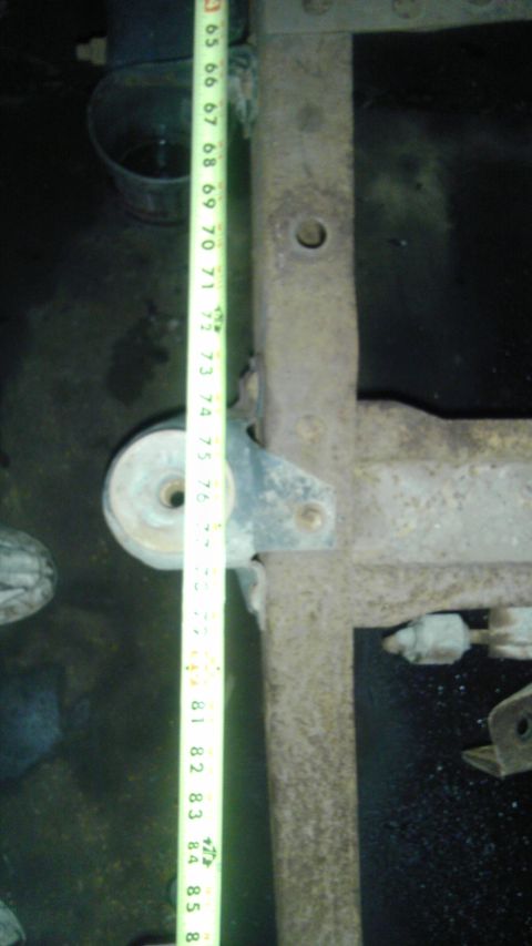 1987 Ford Ranger - Close-up of a rusty truck frame and suspension components with a measuring tape indicating length.