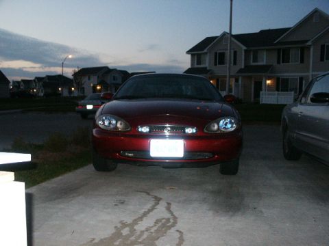 1998 Mercury Sable - A red 1998 Mercury Sable is parked in a driveway at dusk, with houses in the background.