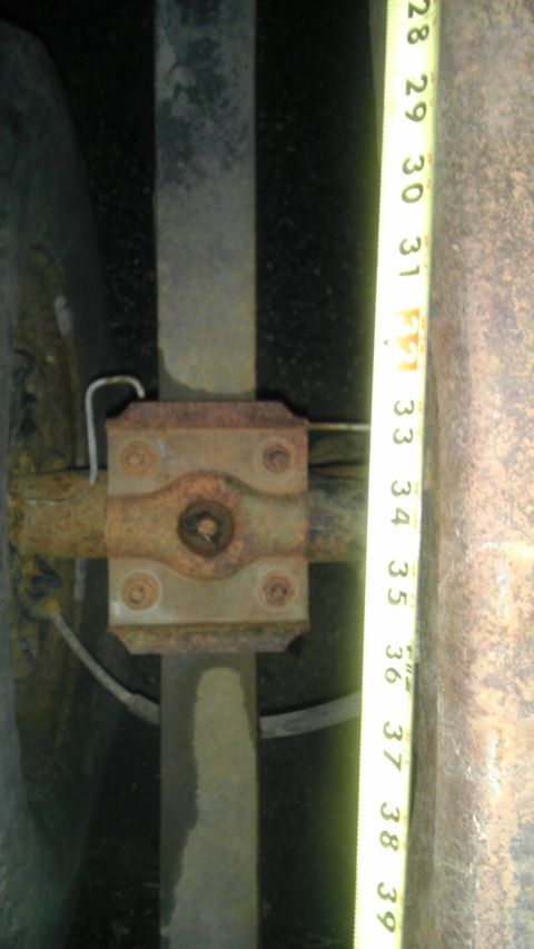 1987 Ford Ranger - A tape measure is used to measure the diameter of a rusty rear axle housing.