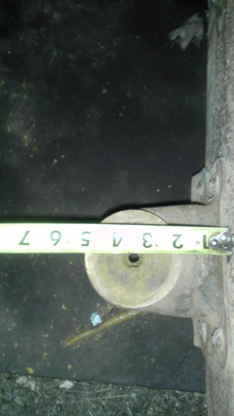 1987 Ford Ranger - A measuring tape is shown across a rusty metal component, likely a part of a vehicle's suspension system.