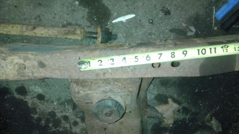 1987 Ford Ranger - Close-up of a rusty metal frame part with a tape measure indicating measurements from 1 to 13 inches.