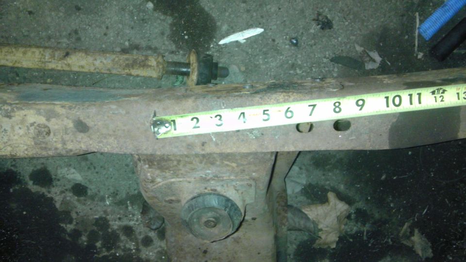 Rusty metal frame section with tape measure showing 1-13 inches