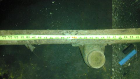 1987 Ford Ranger - A rusted metal part is measured with a tape measure. The part is not a vehicle.