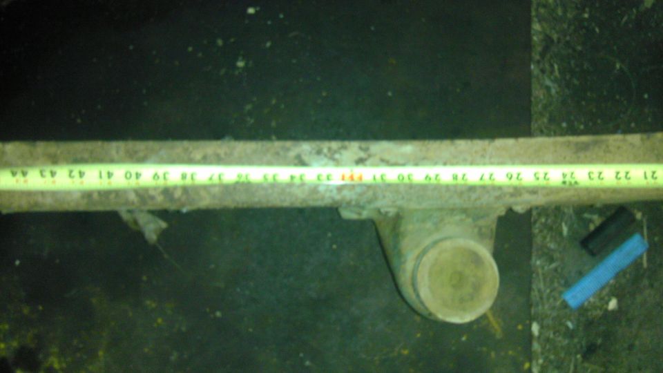 rusted metal component with a yellow measuring tape showing inches 21-44