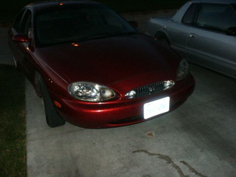 1998 Mercury Sable - A red 1998 Mercury Sable sedan is parked next to a silver car.