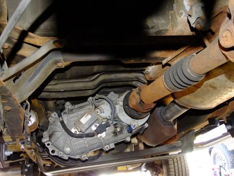 1995 Ford Bronco - Underside view of a vehicle's transfer case and driveshaft, showing mechanical components.