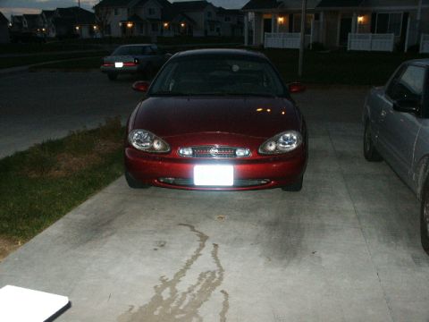 1998 Mercury Sable - Front view of a red 1998 Mercury Sable parked on a driveway with another vehicle beside it.