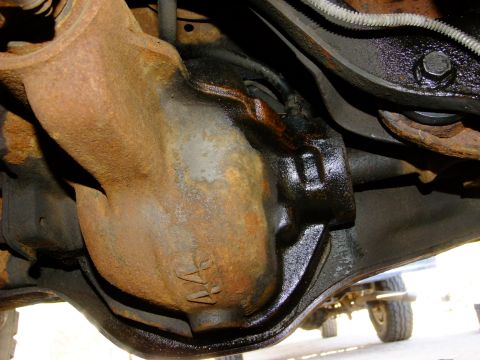 1995 Ford Bronco - Underside view of a vehicle's rear differential housing, showing rust and oil.