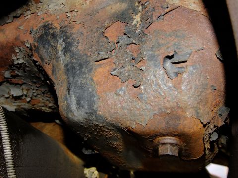 1995 Ford Bronco - Close-up of a corroded metal component, likely from a vehicle's undercarriage.