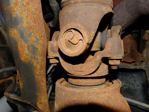 1995 Ford Bronco - Close-up view of a rusty driveshaft universal joint, likely from the rear chassis of a vehicle.