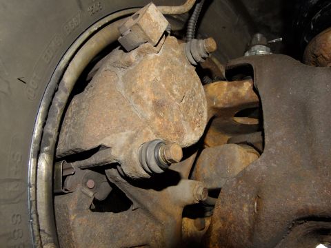 1995 Ford Bronco - This image shows the brake caliper and rotor of a vehicle, with visible rust on the components.