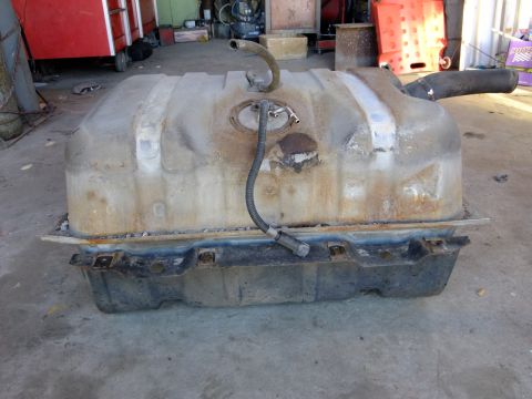 1995 Ford Bronco - A removed fuel tank with associated hoses and filler neck, likely from a vehicle.