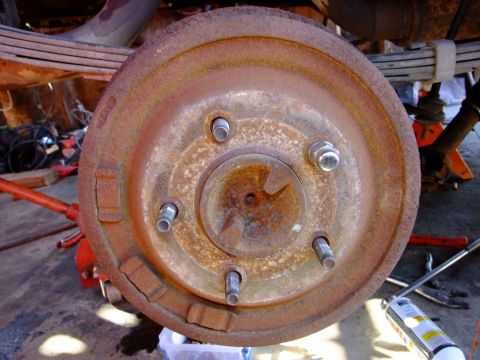 1995 Ford Bronco - Rusty brake drum and suspension components, likely from an older vehicle undergoing maintenance.