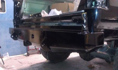 1995 Ford Bronco - The rear of a vehicle is shown, focusing on the bumper and a tire, with some boxes in the background.