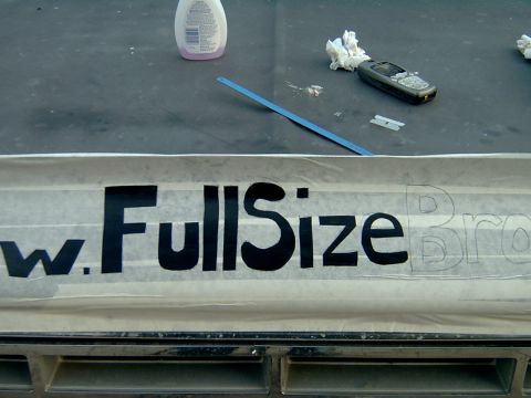 1982 Ford Bronco - A decal is being applied to the hood of a vehicle, with "FullSize" visible and "Bro" outlined.