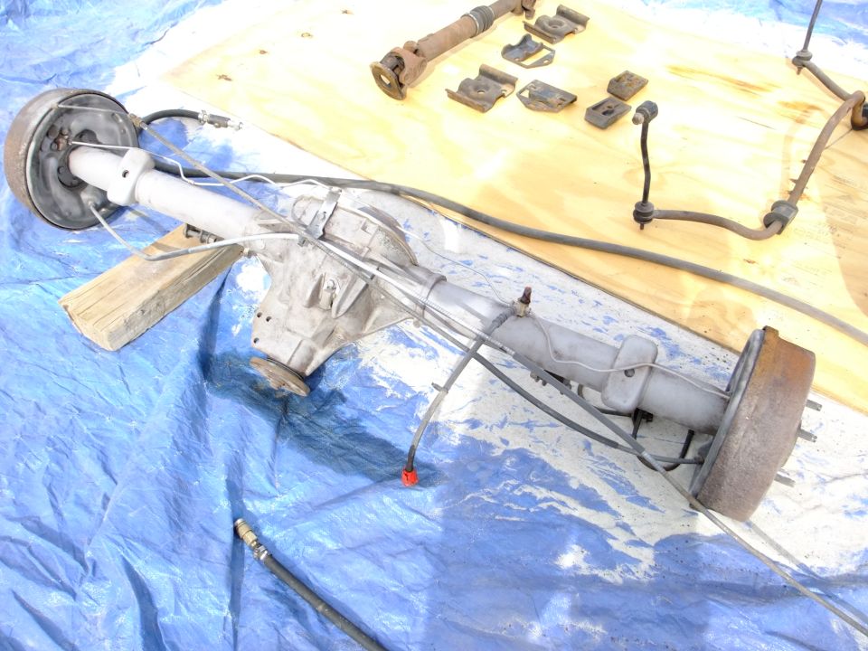 Rear axle assembly with brake drum and driveshaft components