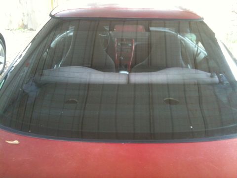 1995 Ford Probe - Interior view of a red car, showing bucket seats and center console through the rear window.