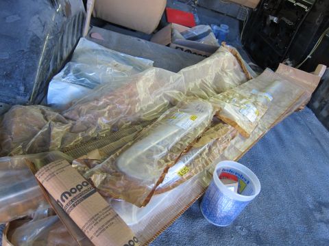 1987 Dodge 1500 - Various Mopar parts are stored in plastic packaging, with some visible labels indicating they are genuine Chrysler parts.