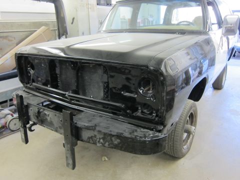 1987 Dodge 1500 - Front view of a black truck undergoing repairs, with its grille and bumper removed.