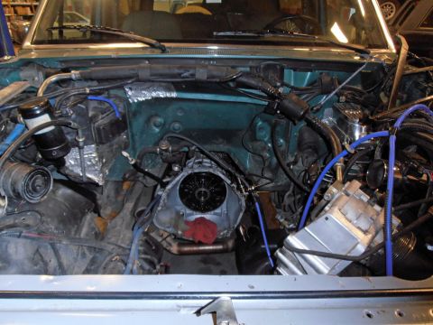 1990 Ford Bronco - The engine bay of a vehicle is shown with the transmission removed, revealing the engine block and surrounding components.