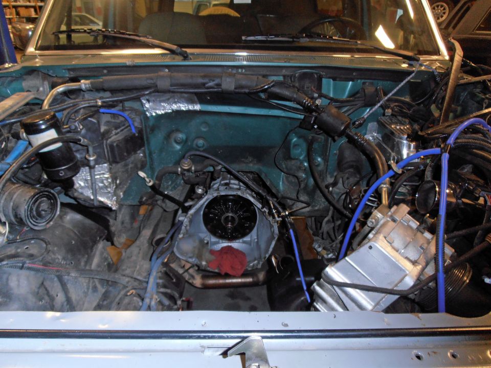 engine bay with transmission removed, showing engine block and various hoses and components
