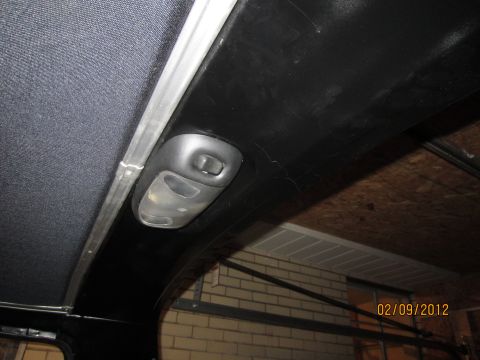 1979 Ford Bronco - The interior overhead light console is visible, showing a dark fabric headliner and a metal trim piece.