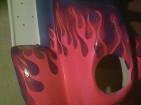 1989 Ford Bronco - This vehicle part features custom flame paintwork in pink and purple, with a circular opening.
