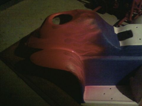 1989 Ford Bronco - A red and blue plastic car dashboard part with a circular cutout is shown from an angled perspective.