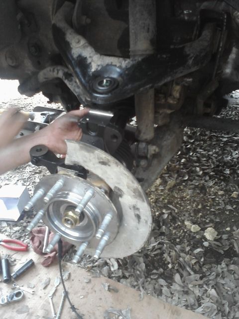 1989 Ford Bronco - Mechanic working on replacing a vehicle's wheel hub and suspension parts.