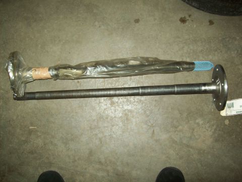 1993 Ford F-150 - Two axle shafts are shown, one is partially wrapped in plastic. A label with text is visible on the lower shaft.