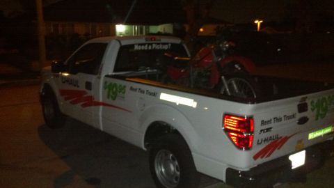 1996 Ford Bronco - A U-Haul truck is loaded with a motorcycle for transport.