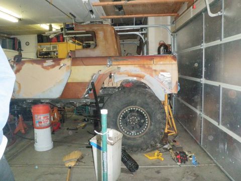 1961 International Scout 800 - A vehicle in a garage, appearing to be in the process of restoration with various tools and parts around it.