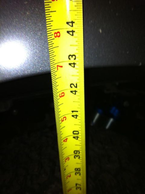 2010 Ford F-150 - A yellow measuring tape is used to measure a part of a vehicle, with markings visible up to 44 inches.