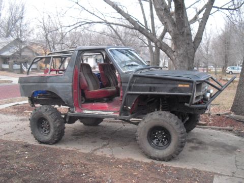 1986 Ford Bronco - This heavily modified SUV features a roll cage and off-road tires, suggesting it's built for terrain.
