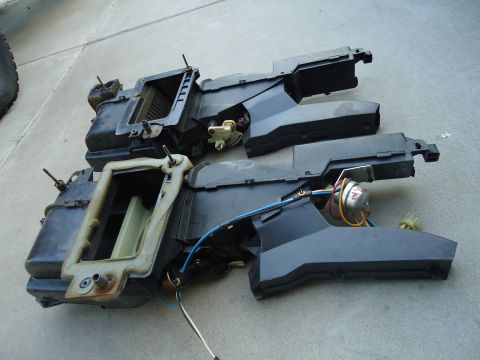 1987 Ford F-150 - Two disassembled vehicle HVAC units are shown on a concrete surface, likely for repair or replacement.