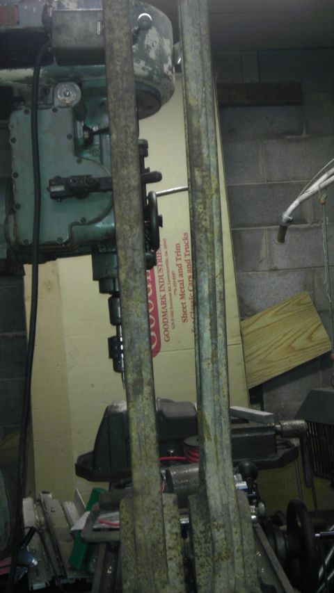 1987 Ford Ranger - Two rusty metal bars are in front of a milling machine and a cardboard box with text.