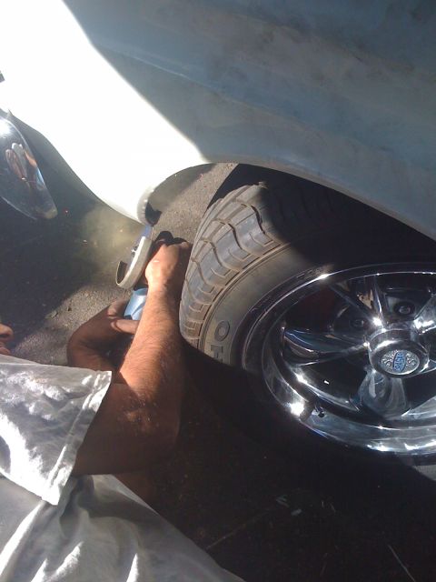1964 Ford Ranchero - A person is working on the front wheel of a vehicle, possibly rolling the fender.