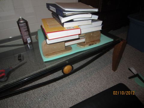1979 Ford Bronco - A collection of books is piled on a table, with various items scattered around the surface.
