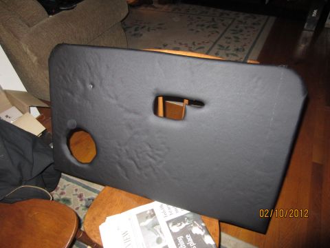 1979 Ford Bronco - A black door panel, likely for a classic vehicle, is shown with a cutout for a window crank and a circular opening for a speaker.