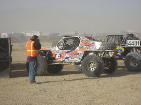 1996 Ford Bronco - A custom off-road buggy, number 22, is parked on a dirt track next to another vehicle during an event.