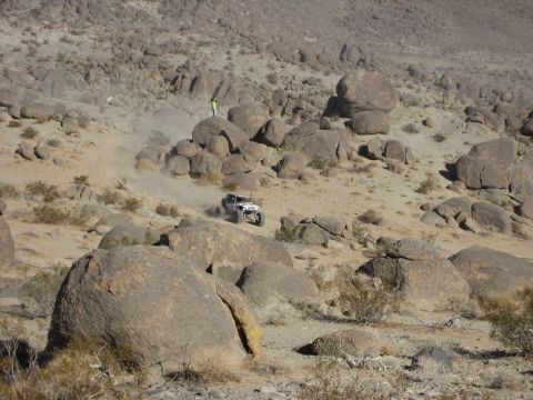 1996 Ford Bronco - An off-road buggy navigates a challenging rocky terrain in a desert environment.