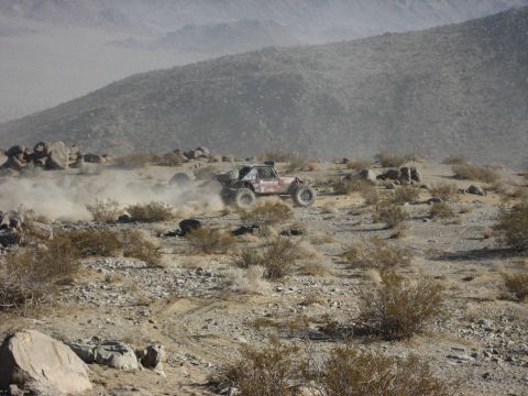 1996 Ford Bronco - An off-road buggy races through a dusty desert landscape.