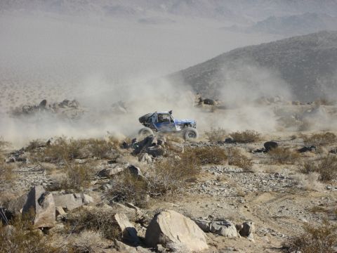 1996 Ford Bronco - An off-road buggy navigates a rocky, dusty terrain during a race.