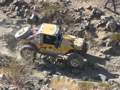 1996 Ford Bronco - This off-road buggy is tackling a challenging rocky incline during an event.