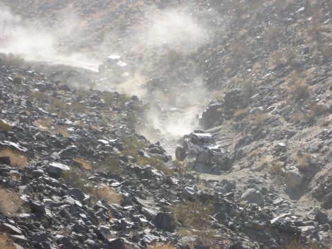 1996 Ford Bronco - Off-road vehicles navigate a dusty, treacherous mountain trail during a race.