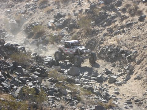 1996 Ford Bronco - A custom-built off-road buggy navigates a challenging, rocky terrain during an event.